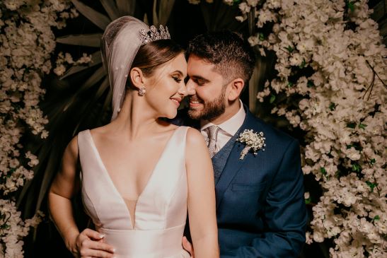 bride and groom smiling on a flowery background